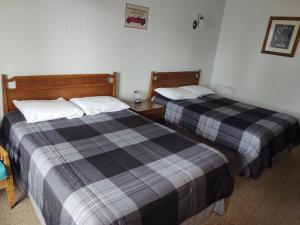 
a hotel room with two beds and two nightstands at FireHouse Inn in Saint Ignace
