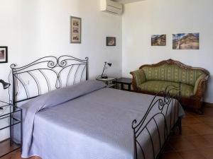 een slaapkamer met een bed en een bank bij Tra Gli Ulivi in Pietra Ligure