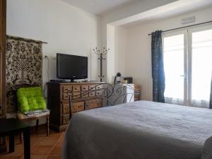 um quarto com uma cama e uma televisão de ecrã plano em Tra Gli Ulivi em Pietra Ligure