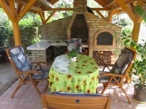 patio ze stołem i piecem ceglanym w obiekcie Kővirág Apartman w Hévízie