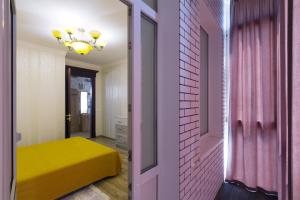 a room with a yellow bed and a pink door at Apart на Вернадського in Dnipro