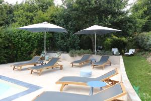 - un ensemble de chaises et de parasols sur une terrasse dans l'établissement Le Chant des Pierres - Entre Terre et Mer, à Pornic