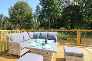 a patio with a couch and a table on a deck at Hollicarrs - Kingfisher Lodge in York