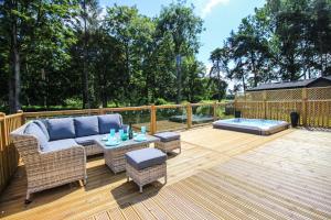 a patio with a couch and tables on a deck at Hollicarrs - Kingfisher Lodge in York
