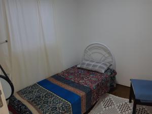 Cama pequeña en habitación con almohada en Casa Container, en Bagé