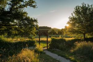 una puerta en un campo con la puesta de sol en La Vallee des Elements, en Chiddes