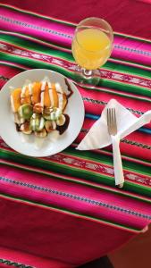 a plate of food and a glass of orange juice at Uros Maya Lodge in Puno