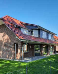 a brick house with an orange roof at Ferienwohnung "Zum Haidmann" in Luhdorf