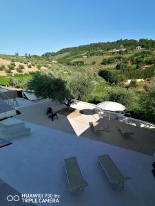 einen Blick über eine Terrasse mit Stühlen und einem Sonnenschirm in der Unterkunft Cantina Loft in Chieti