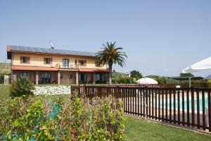 a house with a fence and a palm tree at Casa Vacanza Il Malandrone in Vada