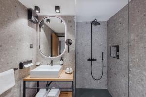 a bathroom with a shower, sink, and mirror at ONE66 Hotel in Ljubljana