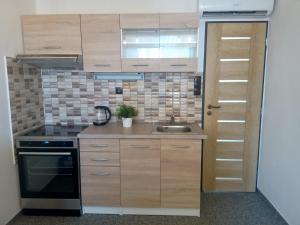 a kitchen with wooden cabinets and a sink and a door at U Hradeb in Mikulov