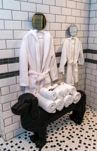 a bathroom with a statue of a dog with towels and robes at Villa Casafina Serviced Apartments in Mangalia +71 photos