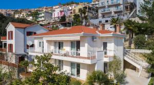 a white house on a hill with apartments at Jadranka in Rabac