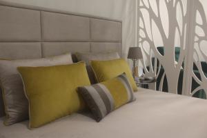 uma cama com almofadas amarelas e cinzentas em Praia Horizonte Studio's - RRAL nº3195 em Praia da Vitória