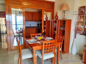 een eetkamer met een tafel en stoelen en een keuken bij Sun Terrace Los Cristianos by HelloApartments in Los Cristianos