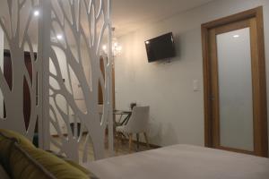 a bedroom with a table and a tv on a wall at Praia Horizonte Studio's - RRAL nº3195 in Praia da Vitória