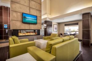 a living room with yellow chairs and a fireplace at Home Inn & Suites Regina East in Regina