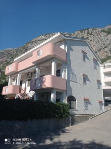 um grande edifício de apartamentos em frente a uma montanha em Apartments Dakovic M em Kotor