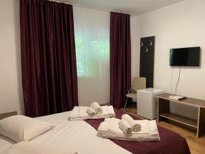 a hotel room with a bed with towels on it at Vila Ana Trident Costinesti in Costinesti
