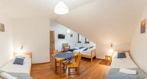 a room with three beds and a table and chairs at Domek Plaster Miodu in Istebna