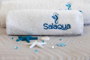 托雷莫泽Salaqua Bed and Breakfast的床上的毛巾,有贝壳和毛巾