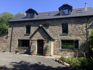 a stone house with two windows on top of it at Little London Bed & Breakfast and Glamping pod in Abercraf