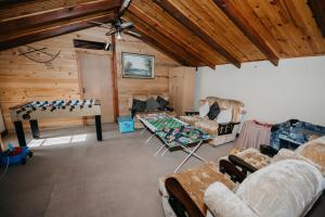 a living room filled with furniture and a wooden ceiling at The Village Lodge in Stormsrivier