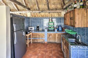 a kitchen with wooden cabinets and a refrigerator at Guatemala Beachfront Villa with Direct Beach Access! in Monterrico