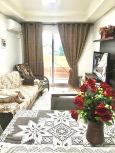 sala de estar con sofá y mesa con flores en Canela - 2 suítes - Vivendas do Lago, en Canela