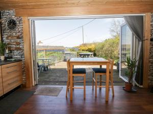 een keuken met een tafel en stoelen en een balkon bij Blackbrae Cabin in Coatbridge