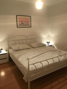 1 dormitorio con 1 cama blanca y 2 mesitas de noche en Villa Maria, en Zadar
