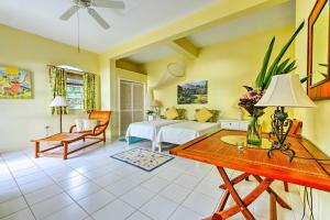 Schlafzimmer mit einem Bett, einem Schreibtisch und einem Tisch in der Unterkunft Nevis Home with Pool, Stunning Jungle and Ocean Views! in Gingerland