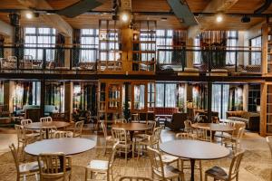 ein Restaurant mit Tischen, Stühlen und Fenstern in der Unterkunft ONE66 Hotel in Ljubljana