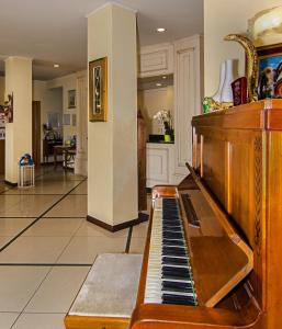 an old piano in a room with a hallway at Hotel Villa Ombrosa in Marina di Pietrasanta