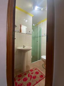 uma casa de banho com um chuveiro, um lavatório e um WC. em Residencial Canadá Praia Grande 100 metros em Ubatuba