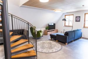 uma sala de estar com uma escada e uma sala de estar com um sofá em 4 Apartments im Hof by Gasthof Linde em Albstadt