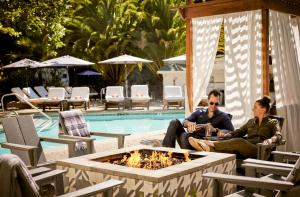 a man and a woman sitting next to a pool at boon hotel + spa - adults only in Guerneville