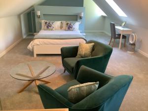 a bedroom with a bed and two chairs and a table at Little London Bed & Breakfast and Glamping pod in Abercraf