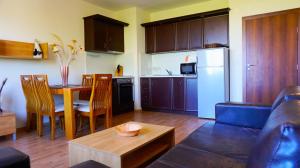 a kitchen and living room with a table and a couch at Апартамент Сънрайз Обзор - Apartment Sunrise Obzor in Obzor