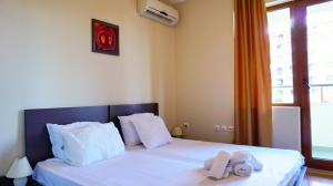 a bedroom with a bed with two towels on it at Апартамент Сънрайз Обзор - Apartment Sunrise Obzor in Obzor