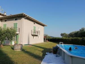 a house with two people in a swimming pool at Bilocale Papavero, Magnolia o Girasole in San Felice del Benaco
