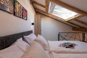 Un dormitorio con una cama con almohadas blancas y una ventana en GAMA Dubrovnik, en Dubrovnik