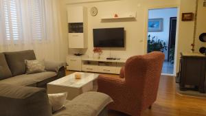 a living room with a couch and a tv at Apartman Nina in Makarska