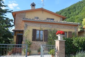 een huis in de bergen met een poort en bloemen bij Villa Mischianti in Gubbio