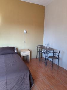 een slaapkamer met een bed en een tafel en stoelen bij Suite amplia privada a 8 min del centro in Aguascalientes