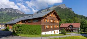 a house in front of a mountain at Ferienbauernhof Berlinger in Au im Bregenzerwald