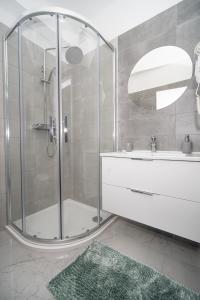 a bathroom with a shower with a sink and a mirror at Villa Apartments Lela in Rabac +33 photos