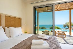 - une chambre avec un lit et une vue sur l'océan dans l'établissement Salvia Luxury Collection Suites, à Skalotí