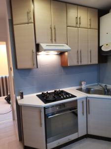 a kitchen with white cabinets and a stove top oven at Apartament Francuski in Krosno